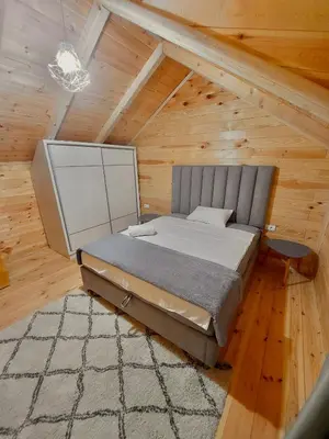 a bedroom with a bed in a wooden attic at Villa Butterfly Valdanos in Ulcinj