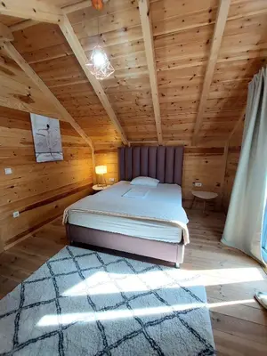 a bedroom with a bed in a wooden room at Villa Butterfly Valdanos in Ulcinj
