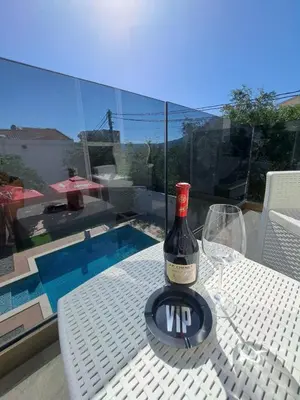 a bottle of wine sitting on a table with a glass at Black & White in Sutomore