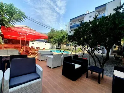 a patio with chairs and tables and a pool at Black & White in Sutomore