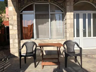 two chairs and a wooden table in front of a window at Апартаменты Jasmine in Bar