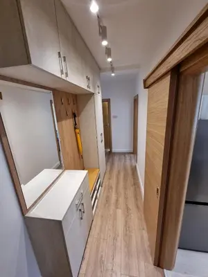 an empty kitchen with wooden floors and cabinets in a room at Golden Fields Apartment near the Old Town in Kotor