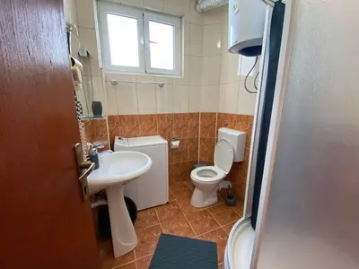 a bathroom with a sink and a toilet and a window at Alina's apartment in Becici