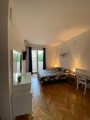 a bedroom with a bed and a desk and a table at Alina's apartment in Becici
