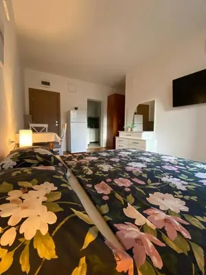 a bedroom with a bed with a floral bedspread at Alina's apartment in Becici
