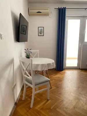 a white table and chair in a room with a window at Alina's apartment in Becici
