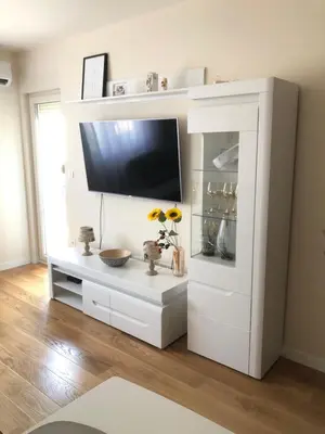 a white entertainment center with a flat screen tv at SunshineLiving, Bar in Bar