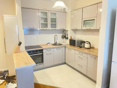 a kitchen with white cabinets and a sink at SunshineLiving, Bar in Bar