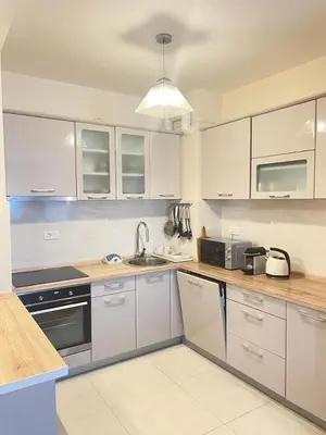 a kitchen with white cabinets and a sink at SunshineLiving, Bar in Bar