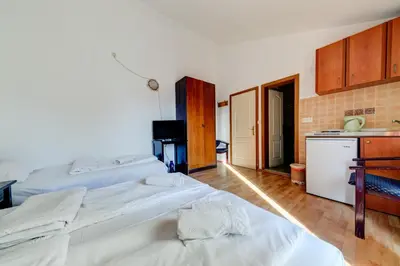two beds in a room with a kitchen at Porta Volta Apartments in Becici