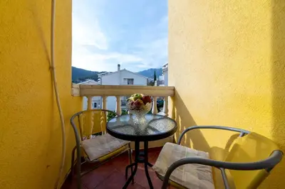a small table with a vase of flowers on a balcony at Porta Volta Apartments in Becici