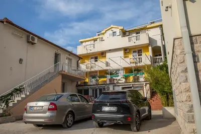 two cars parked in front of a building at Porta Volta Apartments in Becici