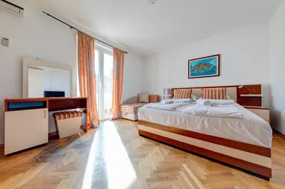 a bedroom with a bed and a desk and a window at Porta Volta Apartments in Becici