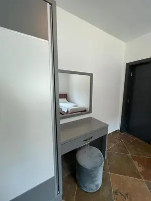 a bedroom with a vanity with a mirror and a stool at Zodea Apartments in Dobra Voda