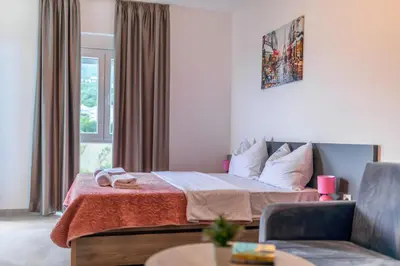 a hotel room with a bed and a chair at Zodea Apartments in Dobra Voda