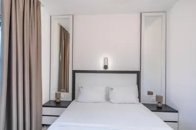 a bedroom with a large white bed with two pillows at Zodea Apartments in Dobra Voda