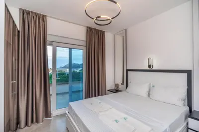 a bedroom with a bed and a large window at Zodea Apartments in Dobra Voda