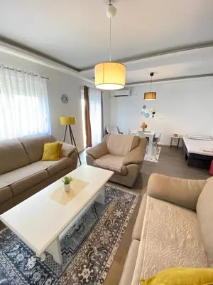 a living room with two couches and a table at Home Mia Airport in Podgorica