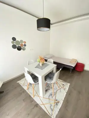 a dining room with a white table and chairs at Home Mia Airport in Podgorica