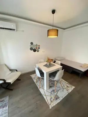 a living room with a white table and chairs at Home Mia Airport in Podgorica