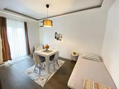 a bedroom with a bed and a table and chairs at Home Mia Airport in Podgorica