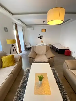 a living room with a couch and a table at Home Mia Airport in Podgorica