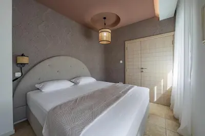 a bedroom with a large white bed and a window at Vila Gina in Bar