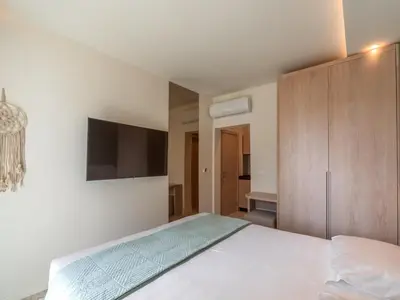a bedroom with a white bed and a tv at Vila Gina in Bar