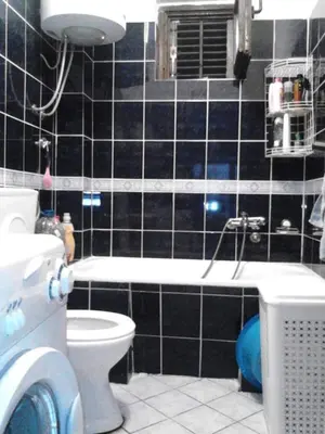 a black tiled bathroom with a toilet and a sink at Studios Milošev in Bar