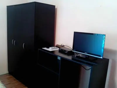 a black desk with a television and a black cabinet at Studios Milošev in Bar