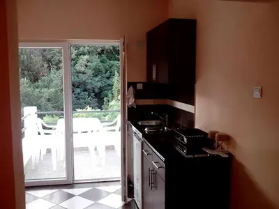 a kitchen with a stove and a door to a patio at Studios Milošev in Bar