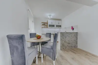 a dining room with a table and blue chairs at Apartmani Vittoria in Bar