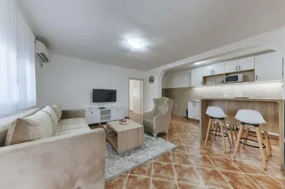 a living room with a couch and a kitchen at Apartmani Vittoria in Bar