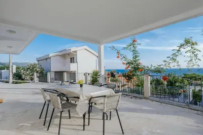 a table and chairs on a patio with a view of the ocean at Apartmani Vittoria in Bar