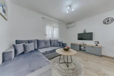 a living room with a blue couch and a table at Apartmani Vittoria in Bar
