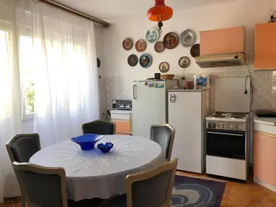 a small kitchen with a table and a refrigerator at Apartment TARGET in Cetinje