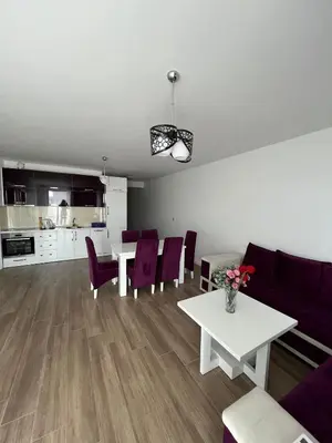 a living room with a white table and purple chairs at Apartments Meri in Dobra Voda