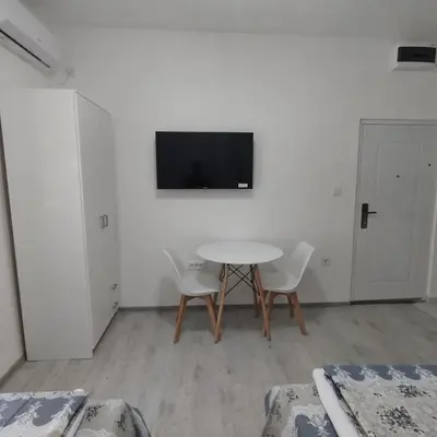 a room with a table and two chairs and a tv at Apartmani 15 in Cetinje