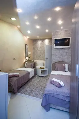 a room with two beds and a tv on the wall at Apartments Lidija in Petrovac na Moru