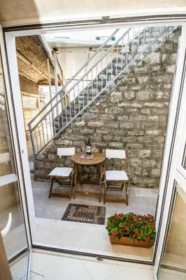 a room with a table and chairs and a staircase at Apartments Lidija in Petrovac na Moru
