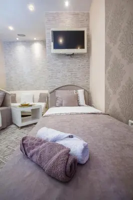 a bedroom with a bed and a tv on a wall at Apartments Lidija in Petrovac na Moru