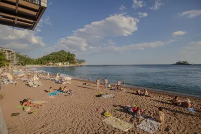 a group of people laying on a beach at Apartments Lidija in Petrovac na Moru