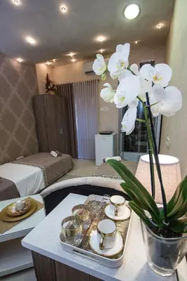 a room with a table with white flowers on it at Apartments Lidija in Petrovac na Moru