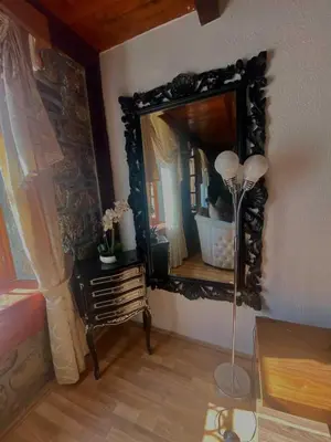 a mirror in a room with a table and a lamp at Vincenza Apartment in Kotor