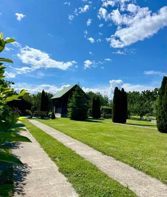 a path through a grassy field with a house at Wooden House - Imanje Terzic in Podgorica