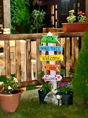 a bunch of signs on a fence with plants at Wooden House - Imanje Terzic in Podgorica