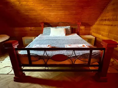 a bedroom with a bed in a wooden cabin at Wooden House - Imanje Terzic in Podgorica
