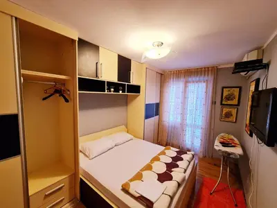 a small bedroom with a bed and a television at Olimp lux III in Budva