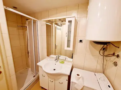 a bathroom with a sink and a shower and a toilet at Olimp lux III in Budva