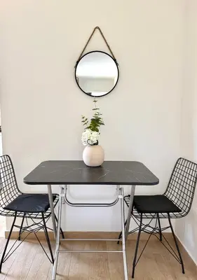 a dining room table with a mirror and two chairs at Danin apartmani in Bar
